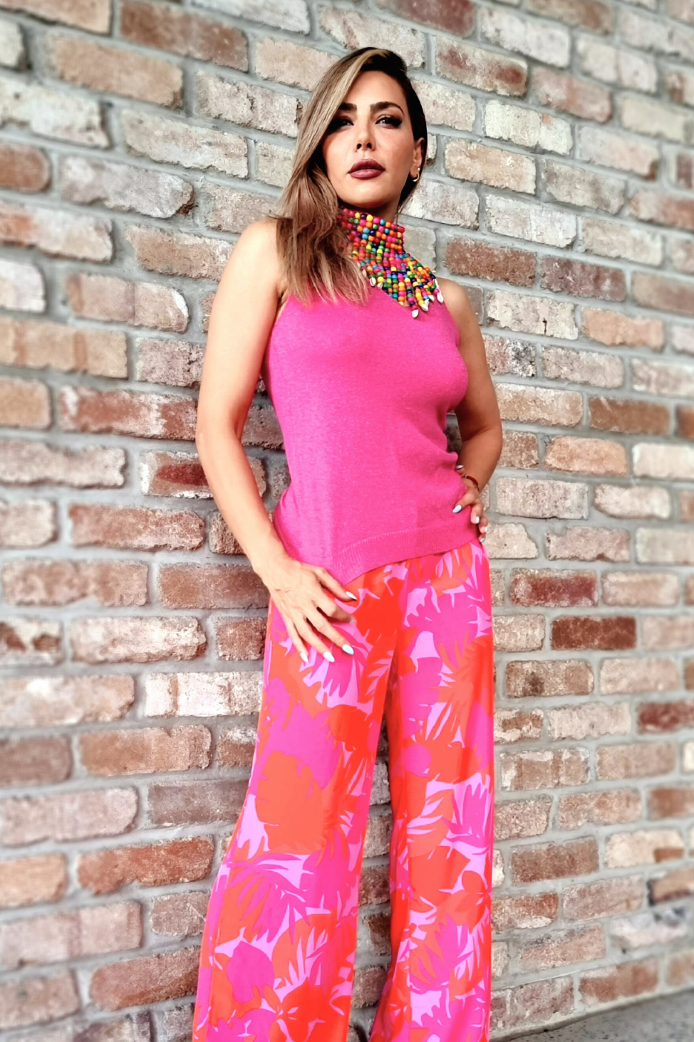 Woman wearing pink and red palm print wide leg pants