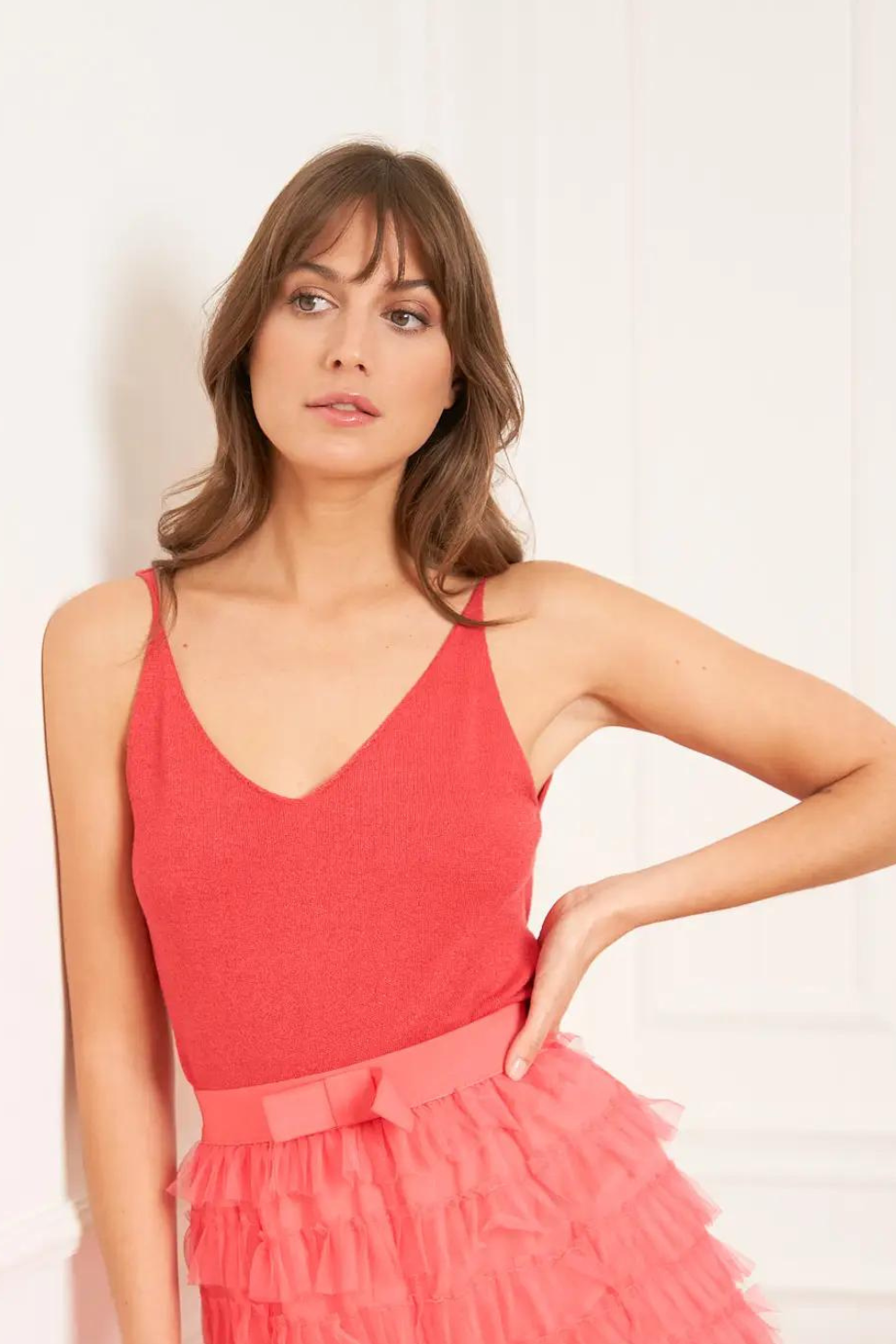 model wearing a coral red tank top