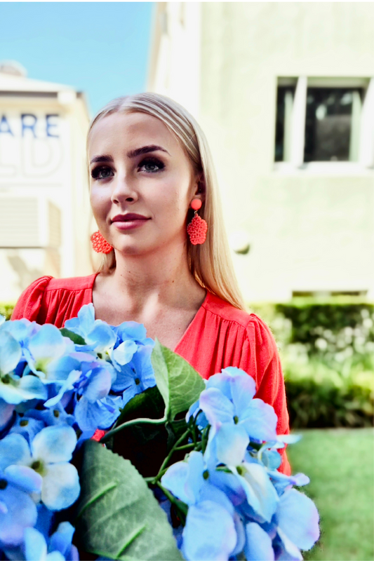 Model wearing Orange beaded flower drop earrings