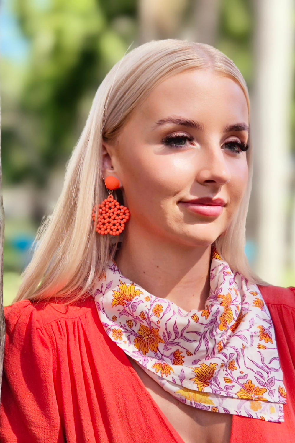 Girl wearing an orange flower neck scarf and orange dress