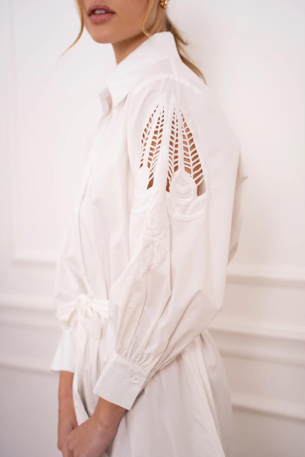 Model wearing a white shirt dress with lace/embroidery detail sleeve