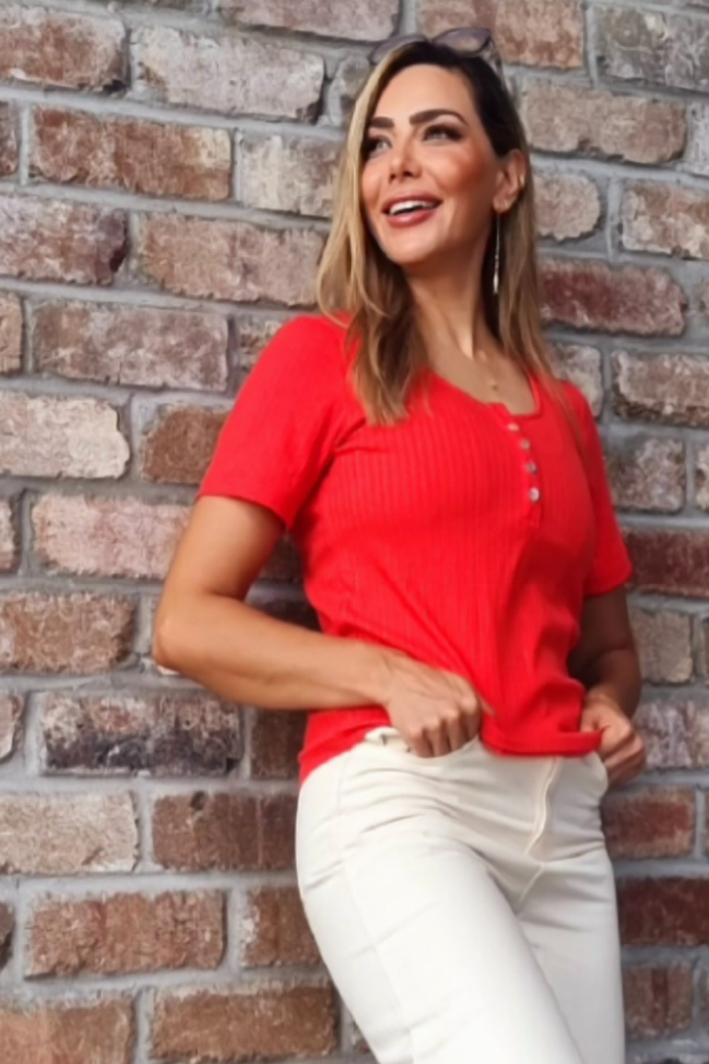 Model wearing a red top with buttons 