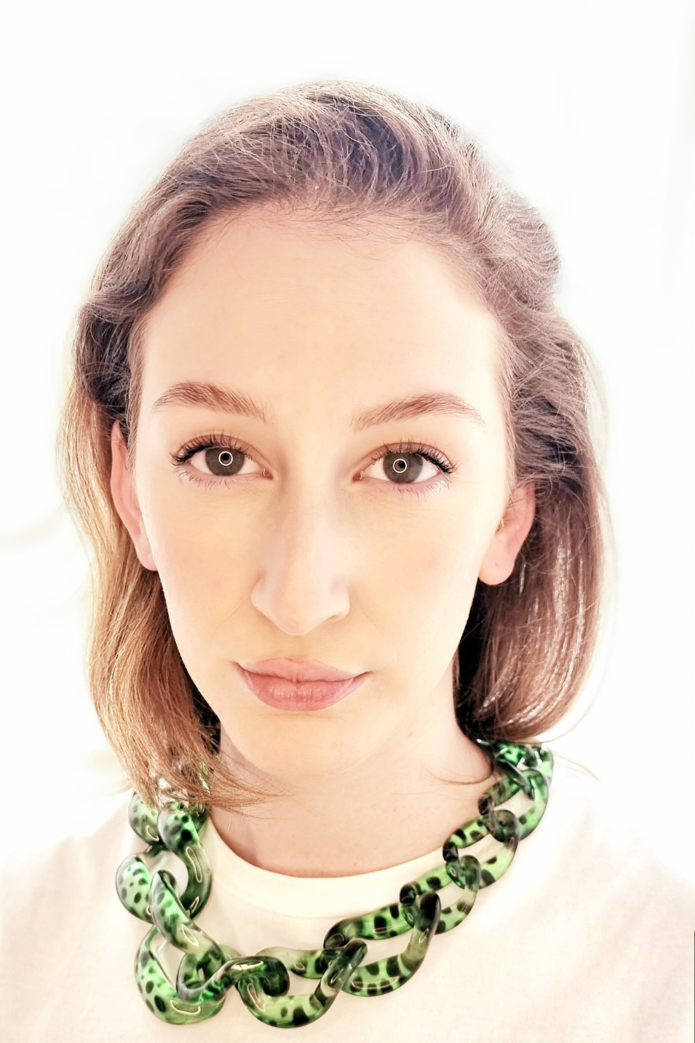 Portrait of a woman wearing a green leopard print chain necklace