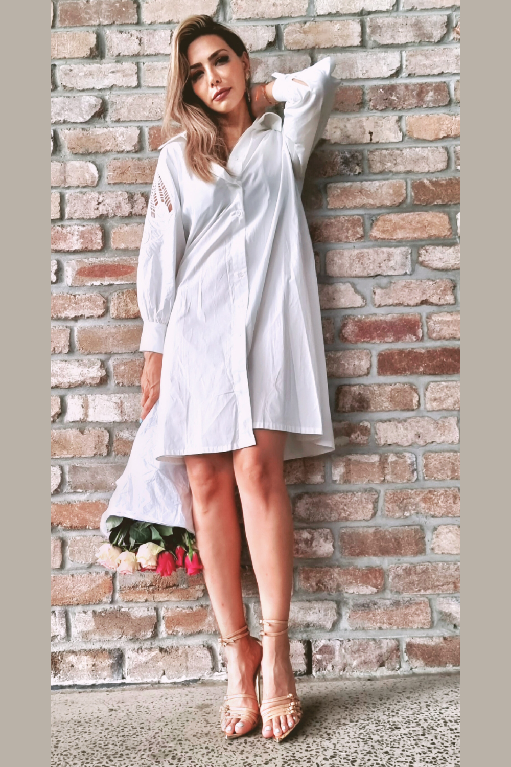 Model wearing a white shirt dress with lace/embroidery detail sleeve