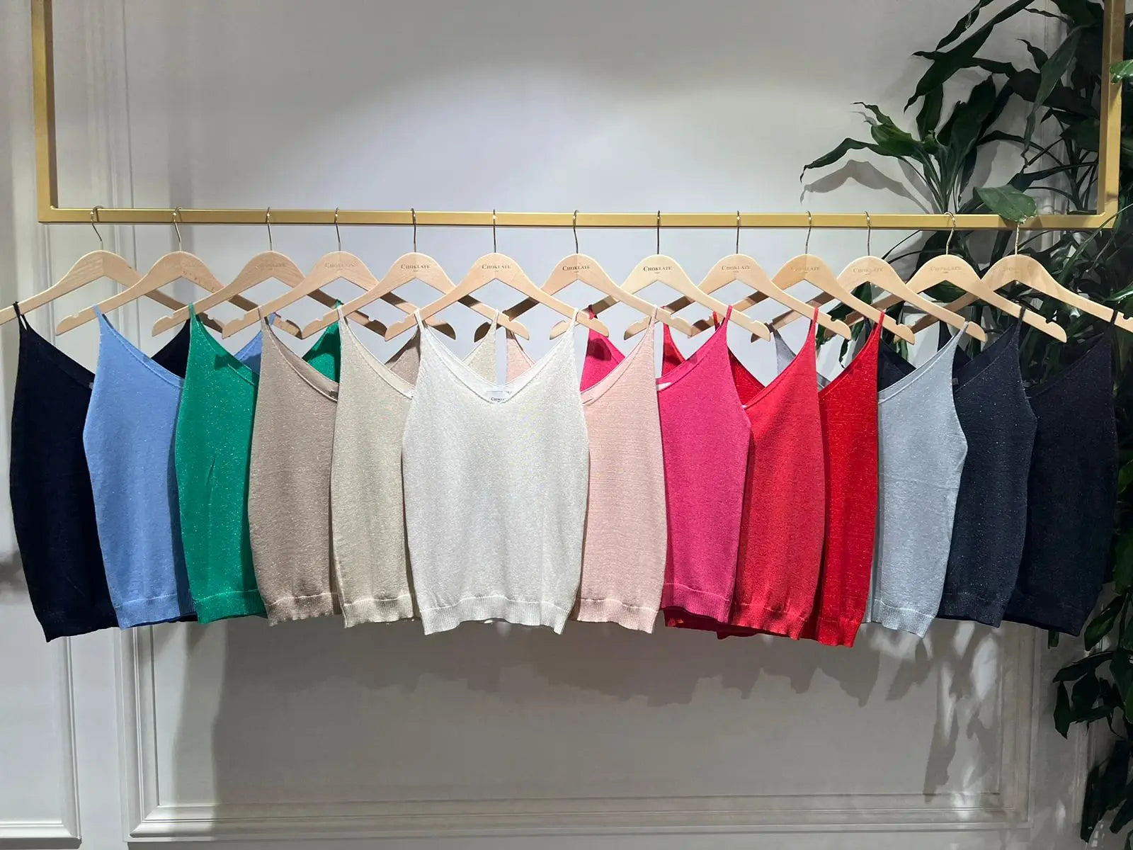 Coloured tank tops hanging on a rail